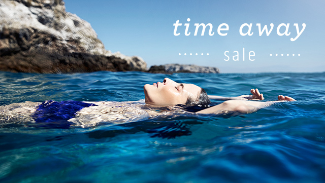 time away sale | Image of a woman laying on her back on the ocean water enjoying the sun