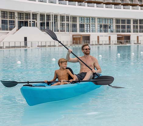 Father and son kayaking in bay 