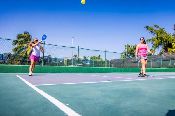 Two girls playing on a pickleball court