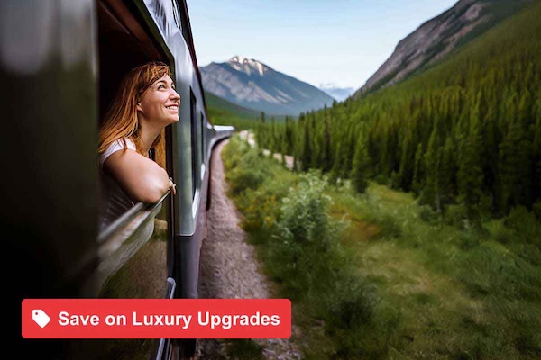 Young smiling woman standing out of the train window while travelling