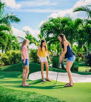 A family playing miniature golf outside.