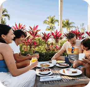 A family eating breakfast outside.